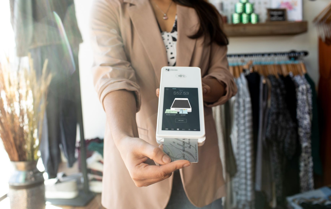 Retail employee assisting a customer with a loyalty or rewards transaction